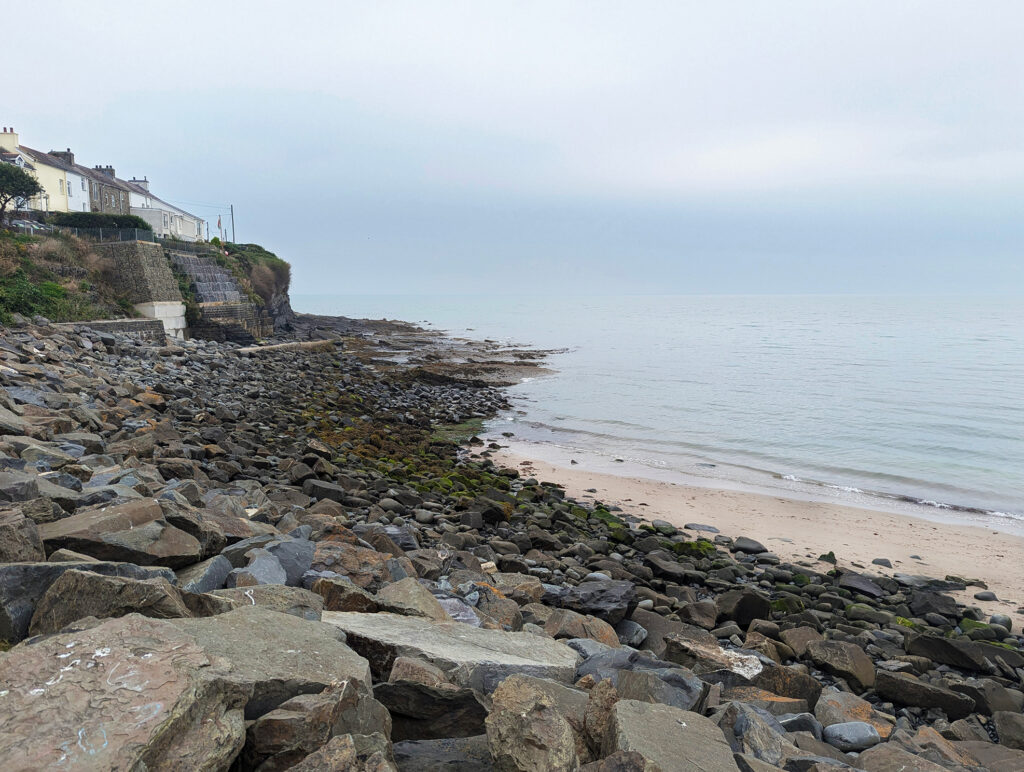 A picture of a beach with many rocks facing the water