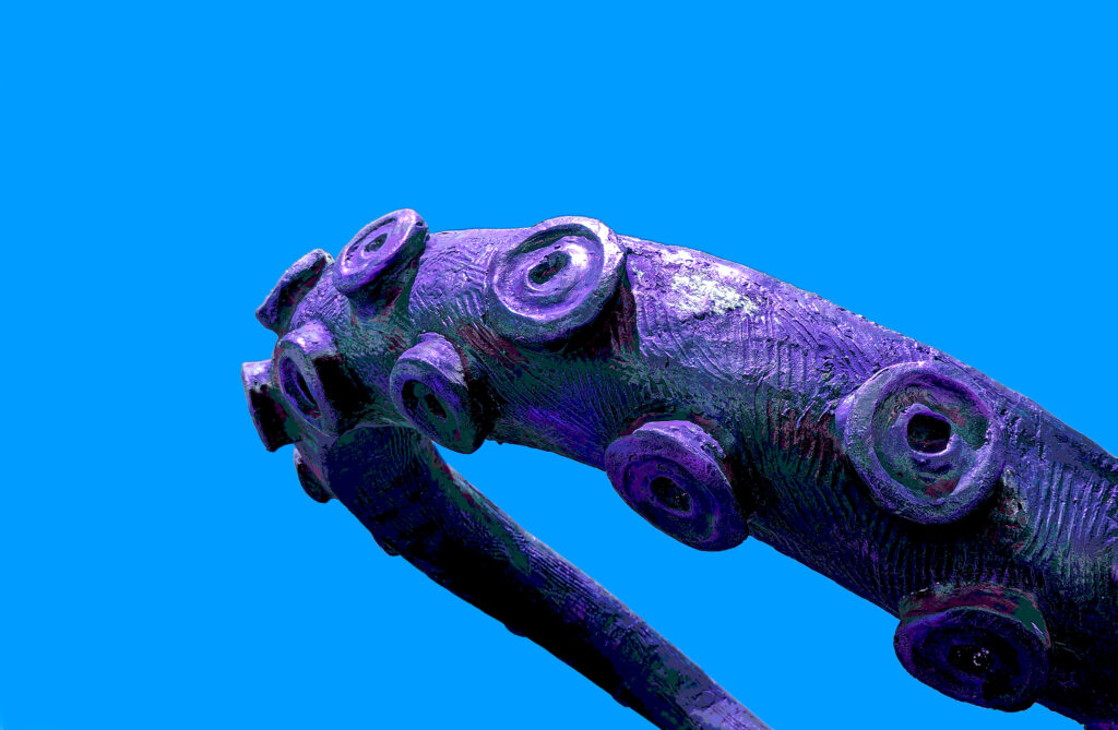 A tentacle from an octopus statue, with hue adjustments to make it look purplish.
