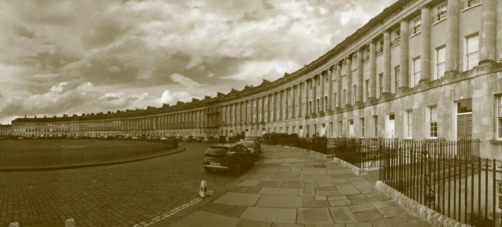 A row of houses in a city with a sepia tone applied to the image and a panoramic view