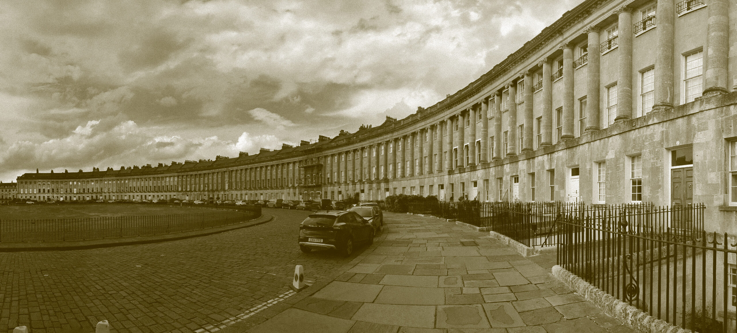 A row of houses in a city with a sepia tone applied to the image and a panoramic view