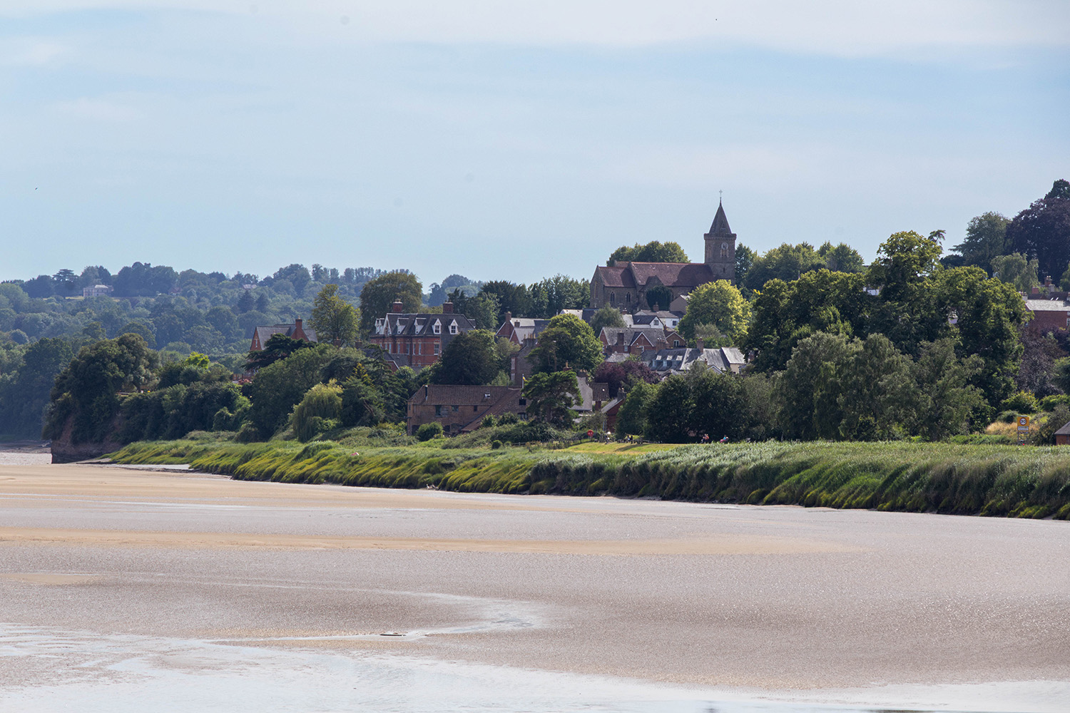 A landscape picture of a small town. You can see a river at a fairly low tide.