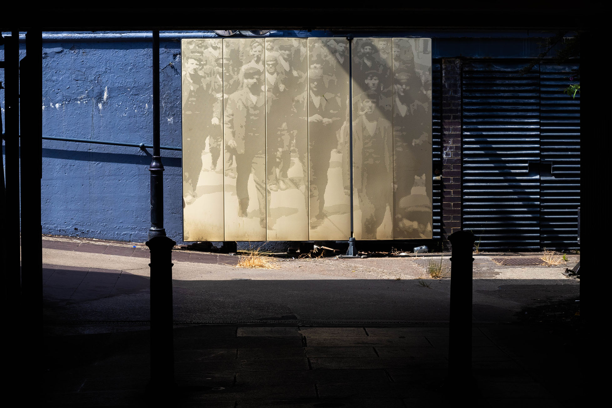 Exit of a tunnel with some sort of artwork of people seemingly boarding the train