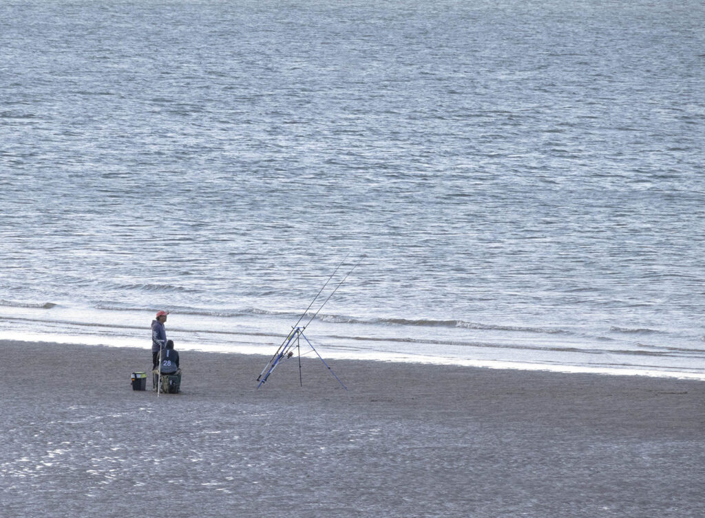 Picture of a fisherman with rods set up at the beach