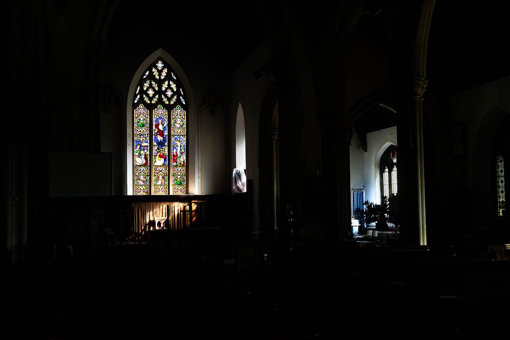 Interior of a church, you can only see the light emitted from two windows